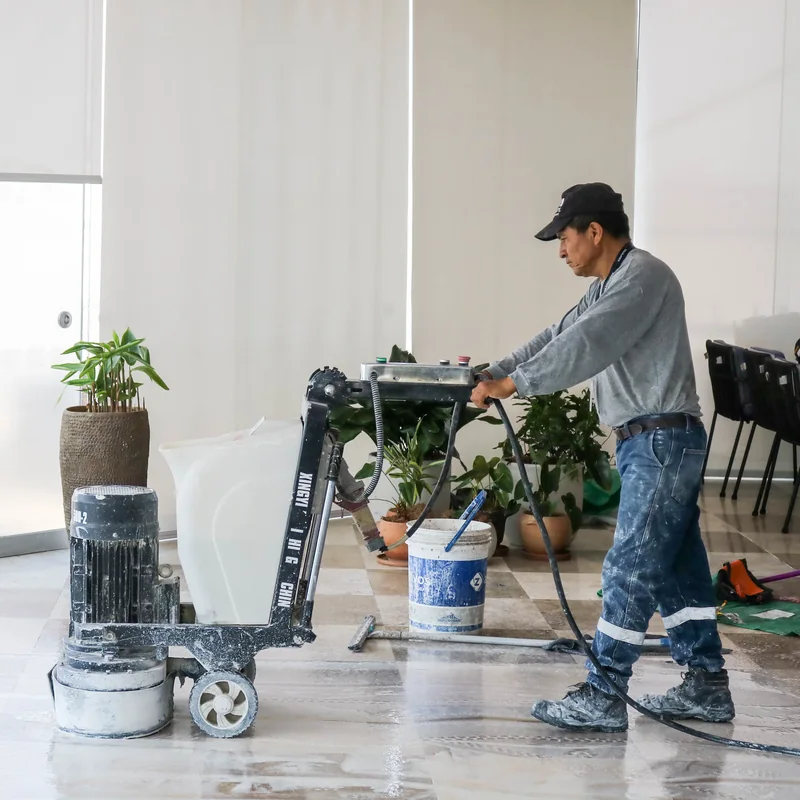 Operador manejando desbastadora y pulidora planetaria industrial